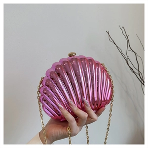 Detail of rose pink metallic shell bag with radial texture and gold chain strap