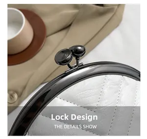 Detail of white quilted shell bag showing metal clasp and vintage ball lock design