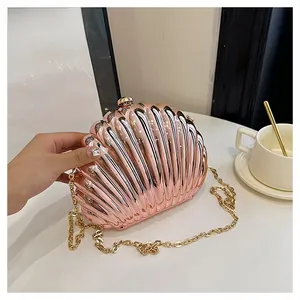 Close-up of rose gold seashell evening clutch with metallic finish and gold chain strap