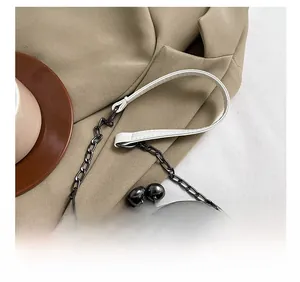 Detail view of quilted shell bag featuring metal clasp closure and chain shoulder strap