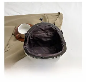 Detail showing the spacious interior and zipper pocket of the white quilted shell bag