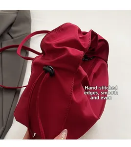 Detail of red drawstring bag showing smooth fabric texture and precise manual stitching