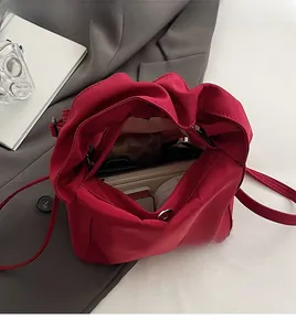 Interior view of red fabric shoulder bag showing spacious storage with magnetic closure
