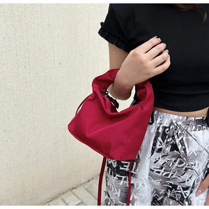 Model showcasing a magenta underarm bag in nylon with stylish natural wrinkles