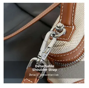 Detail showing the detachable strap and silver metal buckle on the canvas bag