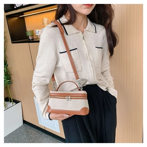Detail of canvas and brown leather stitching on a small crossbody bag for women