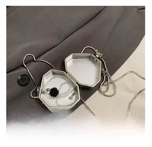 Macro view of silver hexagonal metal mini bag with chain showing interior capacity