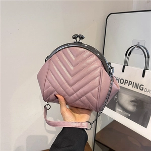 Pink quilted leather shell bag with V-pattern and metal clasp, shown with chain strap