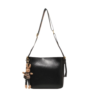Fashionable black bucket bag with a cute rabbit pendant and patterned crossbody strap