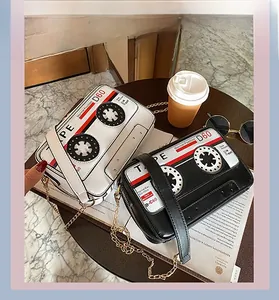Gros plan de sacs bandoulière en forme de cassette rétro en noir et blanc avec chaîne en métal