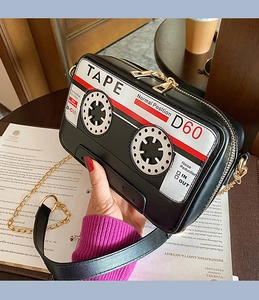 Détail d'un sac à main créatif en forme de cassette rétro avec bandoulière dorée