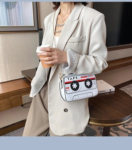 Détail du sac rétro en forme de cassette blanche avec bandoulière chaîne dorée