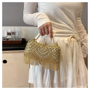 Detailed macro of a luxury gold evening bag with rhinestones and fine metal tassels