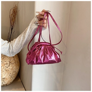 Detailed macro view of the rose pink metallic pleated cloud bag with a glossy finish