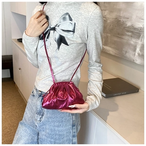 Metallic pink pleated cloud bag with slim crossbody strap shown on a model