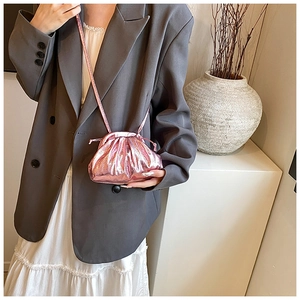 Detailed macro view of a metallic pink dumpling bag with a smooth drawstring closure and thin strap