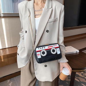 Sac bandoulière créatif en forme de cassette rétro avec chaîne dorée porté par un mannequin