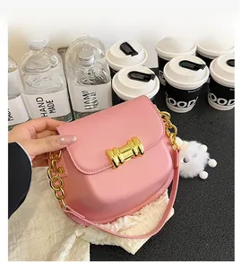 Dettaglio della borsa in pelle rosa con chiusura dorata, catena e ciondolo coniglio