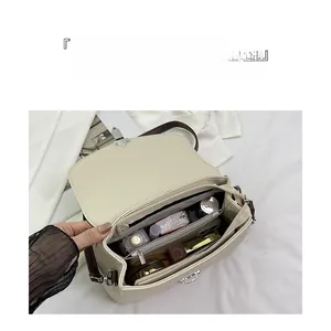 Detailed interior of a beige leather bag showing large capacity and divided compartments