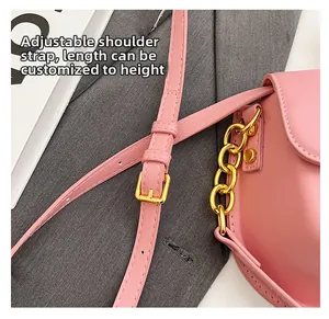 Dettaglio borsa in pelle rosa con tracolla regolabile e catena in metallo dorato