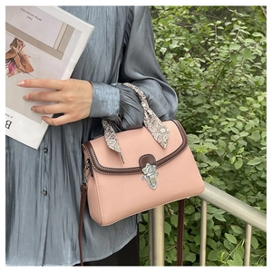 Detail of pink lychee leather handbag with floral silk scarf handle and silver carved buckle