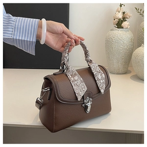 Detail of coffee brown lychee leather handbag with silver lock and paisley silk scarf