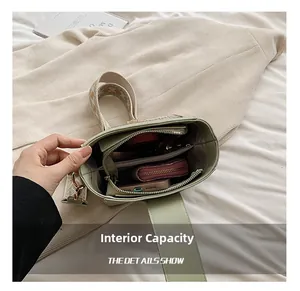 Detail show of light green crossbody bag interior capacity with embroidered strap