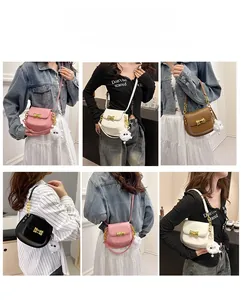 Mini borse a sella in rosa, bianco, marrone e nero con catena in metallo e pon pon