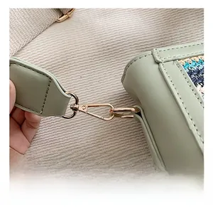 Detail of mint green PU leather bag featuring colorful woven side trim and gold metal hook