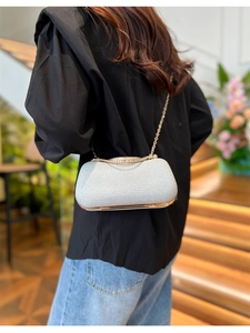 Détail du sac de soirée pailleté argent avec chaîne dorée et décor en strass