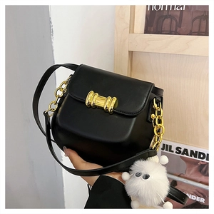 Borsa a tracolla nera con chiusura a fiocco dorato, catena e ciondolo di peluche