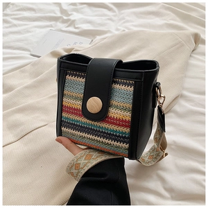 Detail of colorful striped woven crossbody bag with black leather and wide ethnic strap