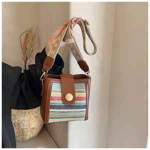 Detailed close-up of woven crossbody bag with vibrant stripes and embroidered strap