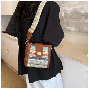 Detail of bohemian striped woven bag with wide patterned strap and wooden buckle