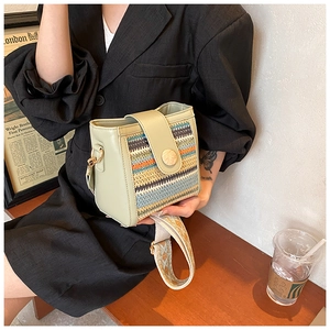 Detail of green crossbody bag with colorful woven texture and ethnic wide shoulder strap