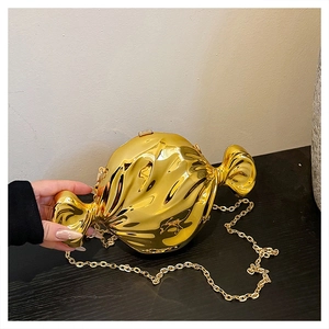 Detailed view of candy-shaped mirror gold evening clutch with elegant chain strap