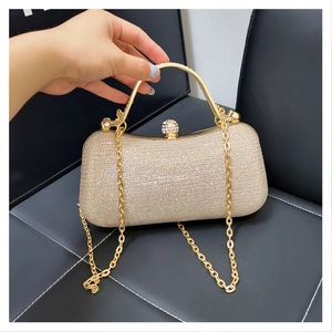 Détails de la pochette de soirée dorée avec paillettes et fermoir de luxe en diamant rond