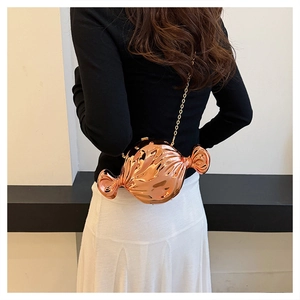 Detail of candy-shaped rose gold crossbody bag with metallic finish and gold chain strap