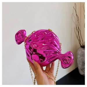 Detail of candy-shaped clutch bag in rose pink with shiny finish and gold chain