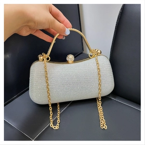 Détail du sac de soirée argenté à strass avec poignée dorée et fermoir diamant scintillant