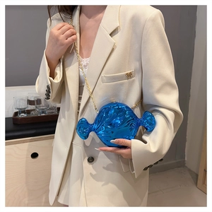 Close-up of a creative electric blue candy-shaped hard shell clutch with a gold chain