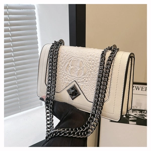 Detail of off-white crossbody bag featuring crocodile texture and dark grey chain strap
