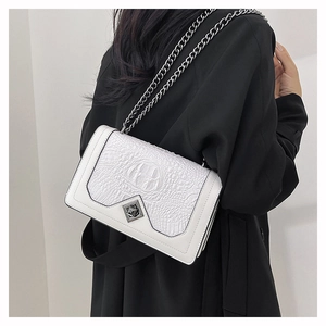 Detailed view of white crocodile pattern crossbody bag with gunmetal chain strap