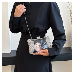 Detail of transparent acrylic evening clutch with silver rhinestones and metal chain