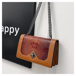 Detail of crocodile texture flap and triple-layered accordion structure on chain bag