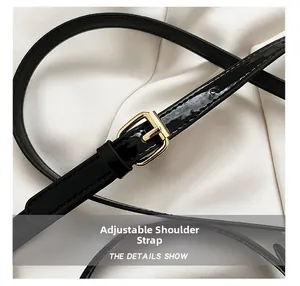 Détail de la bandoulière réglable en cuir verni noir avec boucle dorée polie
