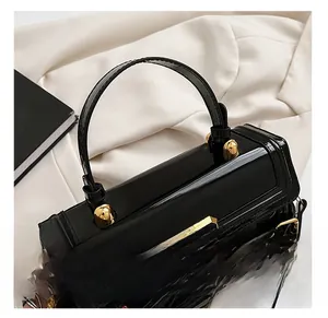 Détail de sac à main en cuir verni noir brillant avec charnières en métal doré chic