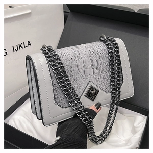 Detailed view of grey faux crocodile leather bag with thick black metal chain and flap