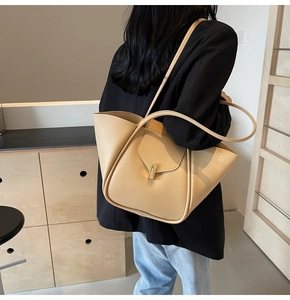 Détail d'un sac cabas en cuir beige avec design plissé et fermoir métallique élégant
