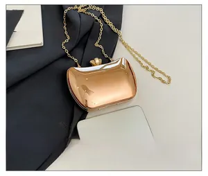Mini metallic evening clutch bag with gold chain showing size comparison to a smartphone